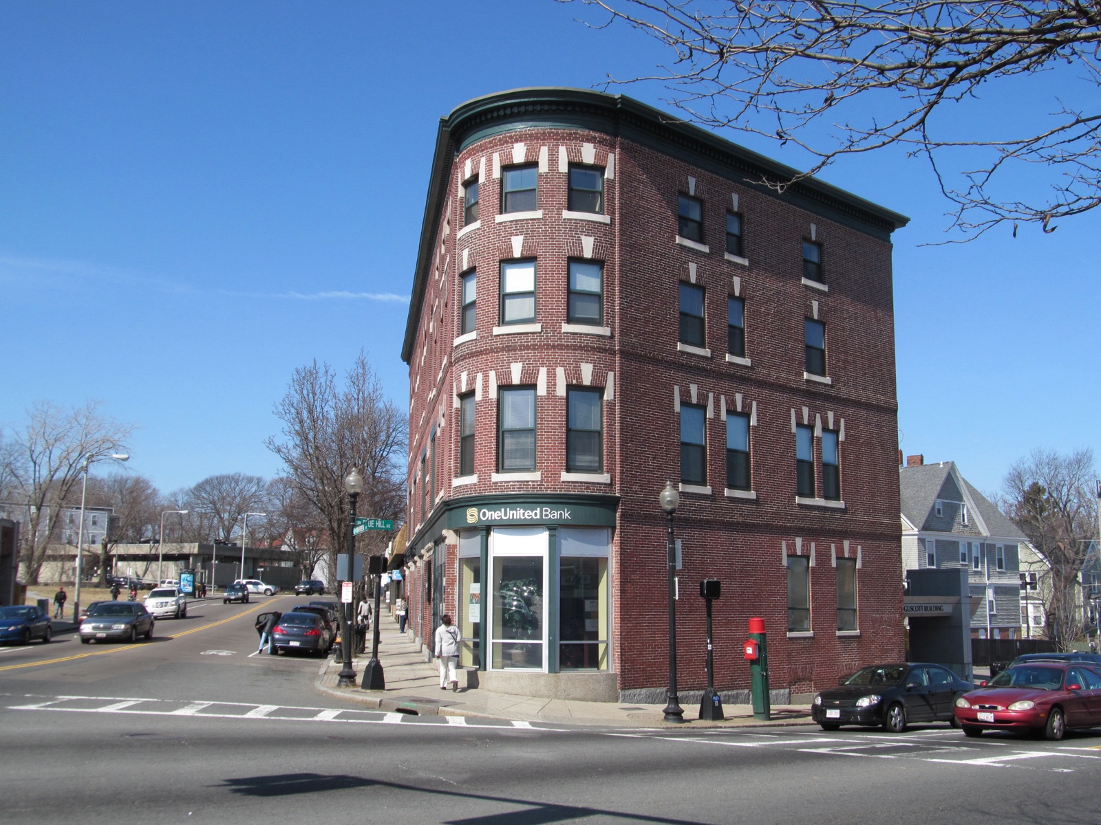 Three-story brick OneUnited Bank building on the corner of Blue Hill Avenue in the Grove Hall section of Dorchester Boston near Pure Oasis