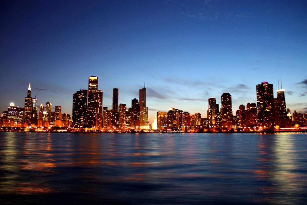 Chicago skyline at dusk seen from Lake Michigan with the Loop towers and lakefront, the city's adult-use cannabis dispensaries cluster between the Loop and the North Side