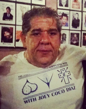 Stand-up comedian Joey Coco Diaz wearing a Joey Coco Diaz t-shirt, the cannabis patriarch of late-era stand-up and longtime podcast staple.