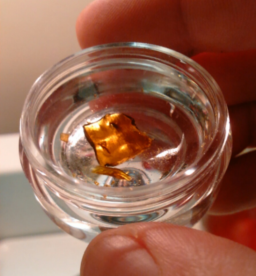 Cannabis shatter concentrate sitting in a small glass jar representative of the Insa concentrate program from the Easthampton processing facility