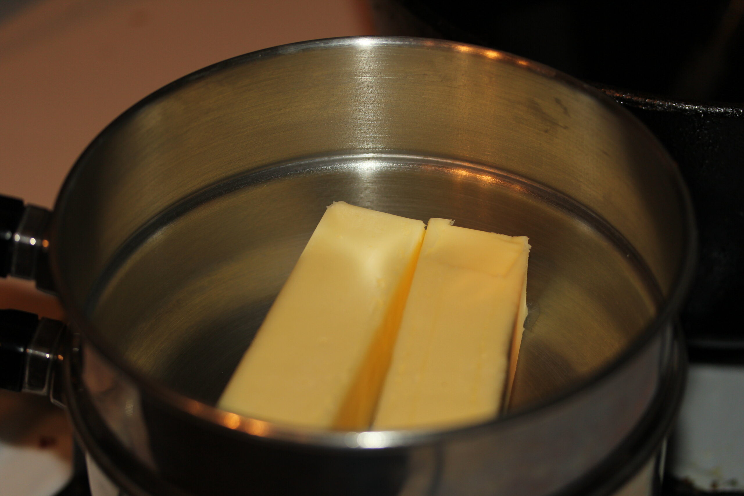 Sticks of butter melting in a stainless steel saucepan, representative of the slow-simmered triple-strained cannabutter Sweet Grass Kitchen has used as the base for its baked edibles since 2009