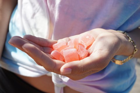 Cannabis-infused fruit gummies in the palm of a hand, representative of the craft edible category Tribute produces in New York