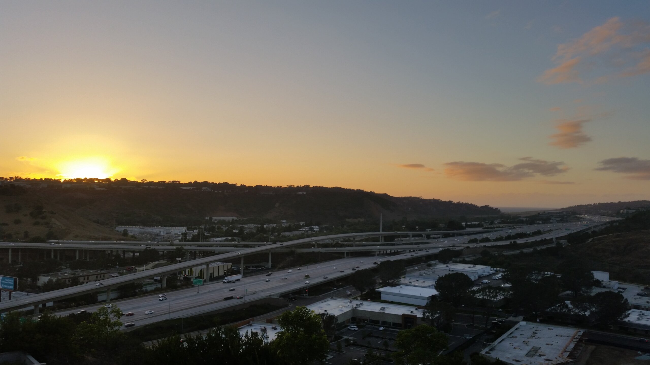 Sorrento Valley San Diego at sunset with Torrey Pines ridge shadow over the Interstate 805 freeway and business park rooftops