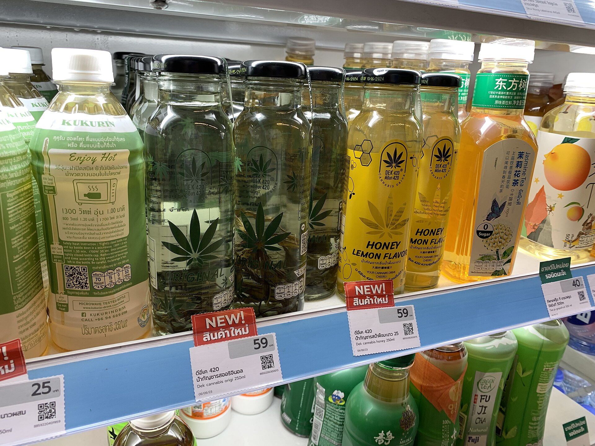 Bottled cannabis-branded drinks on a refrigerated convenience store shelf in Bangkok